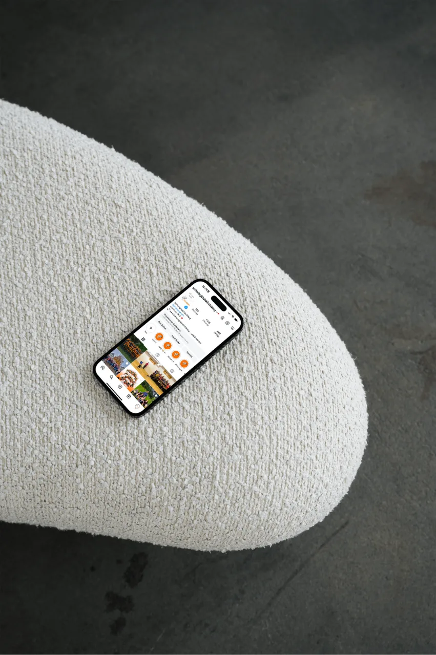 Instagram-Profil auf dem Handy, auf einem Pouf in Szene gesetzt
